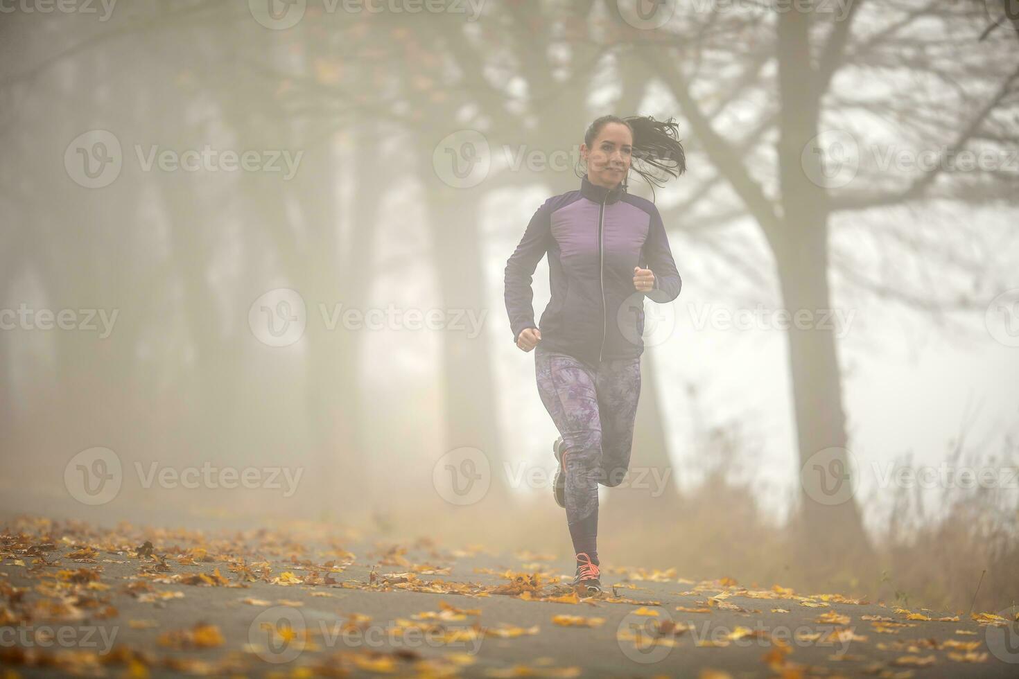 sportlich Frau Laufen im nebelig Herbst Natur foto