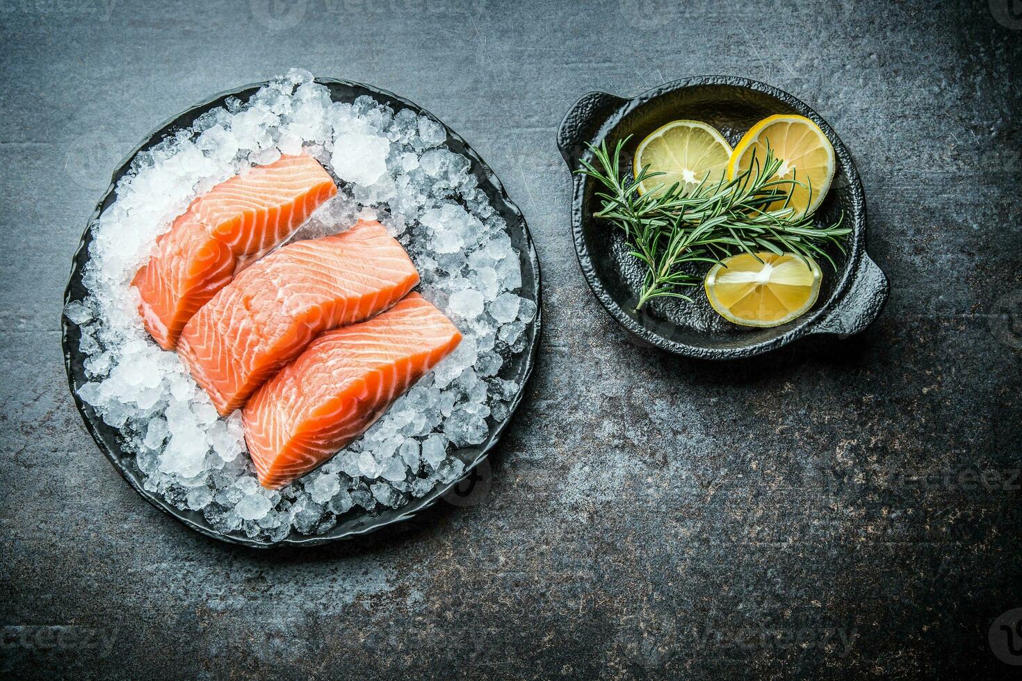 portioniert roh Lachs Filets im Eis auf Teller mit Zitrone und Rosmarin foto