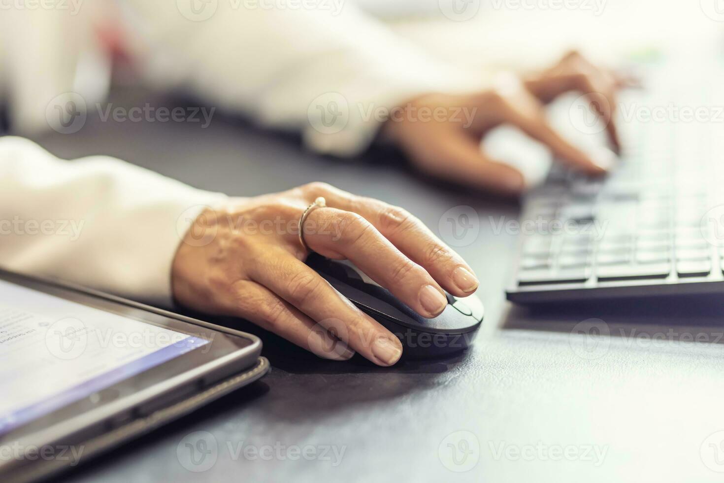 Hände von Geschäftsfrau halten Computer Maus und Tastatur im Büro foto