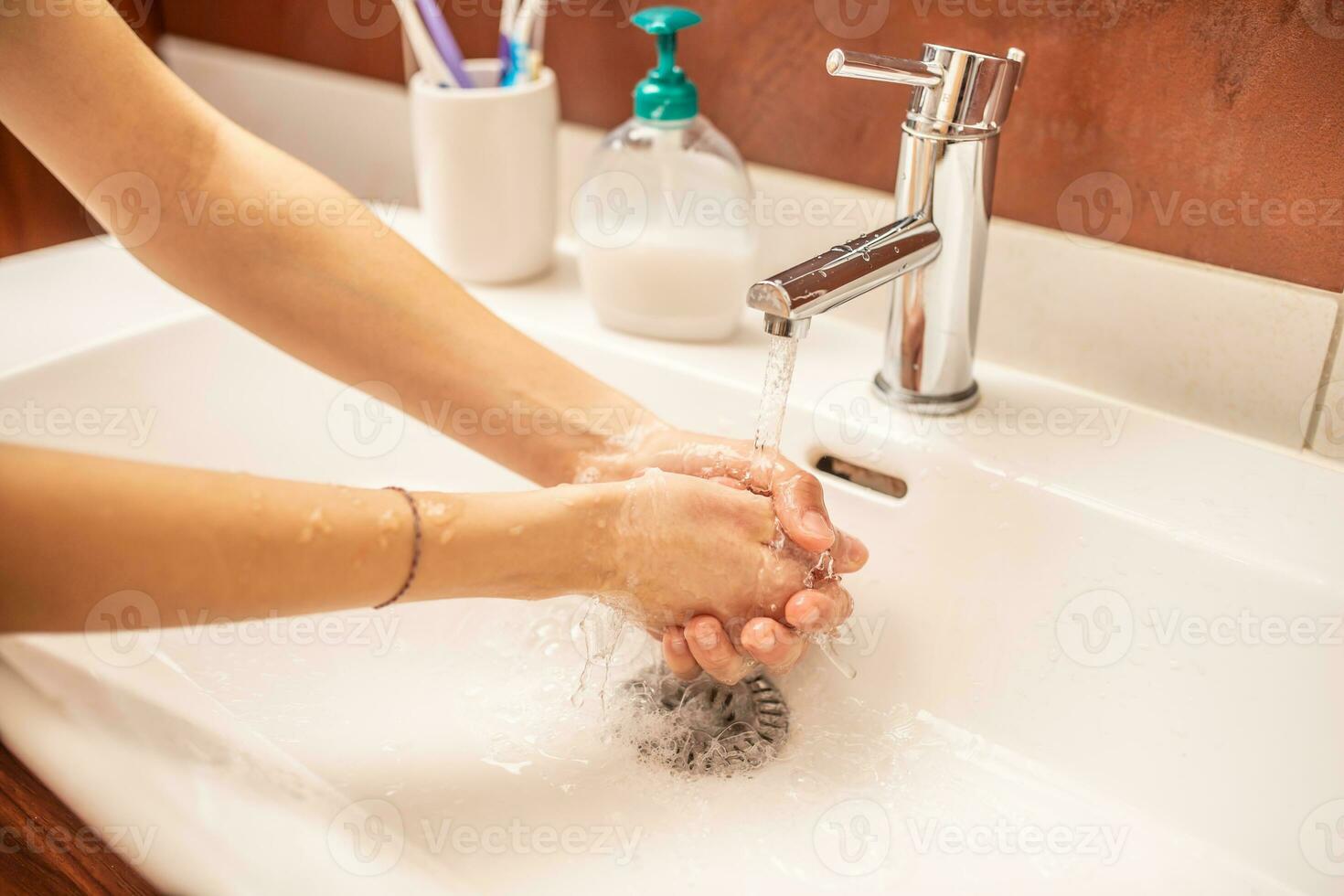 Waschen Hände mit Wasser und Flüssigkeit Seife im das Badezimmer foto