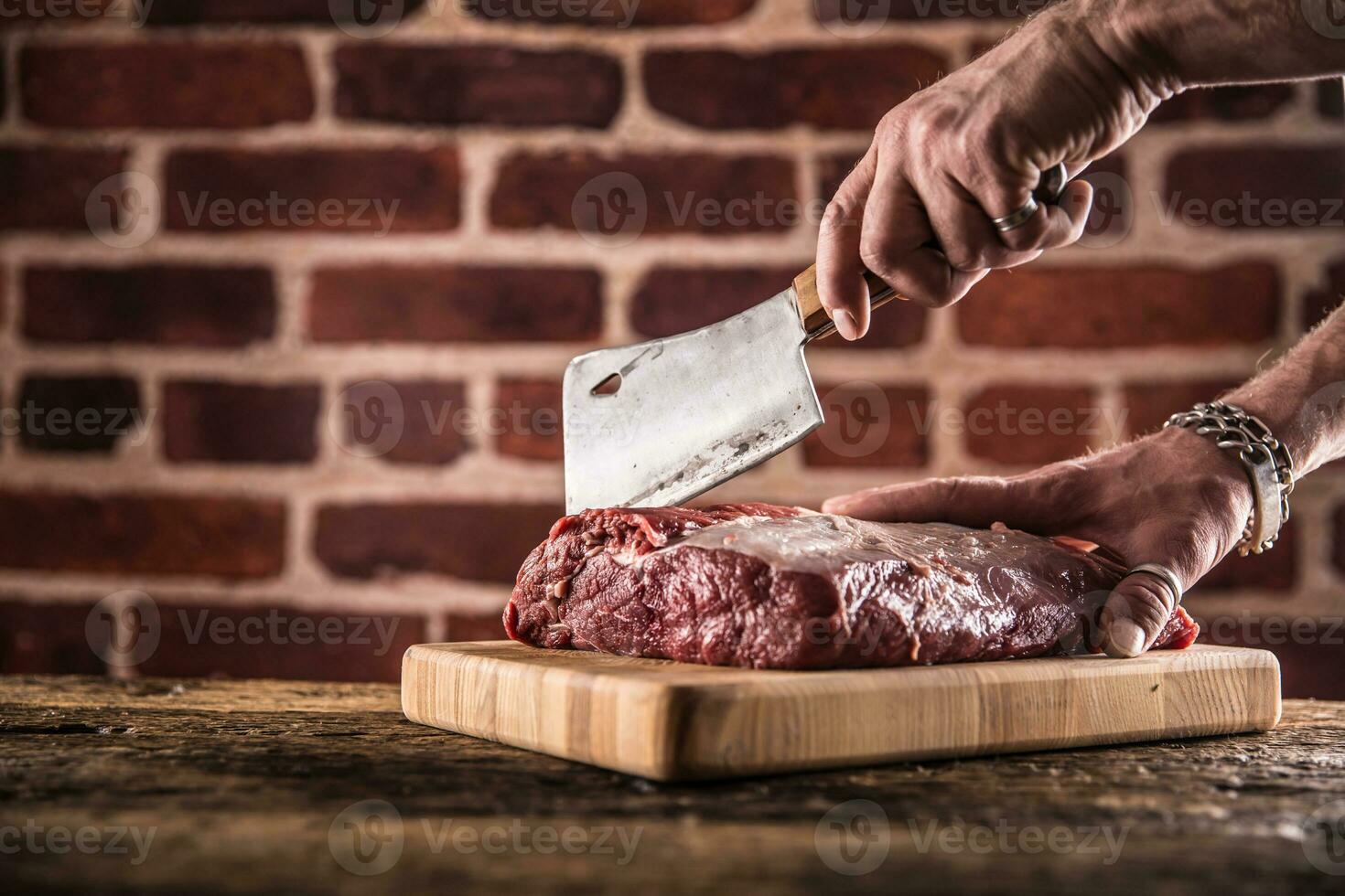 Metzger Mann Hände Schneiden roh Rindfleisch Steak im Metzgerei foto