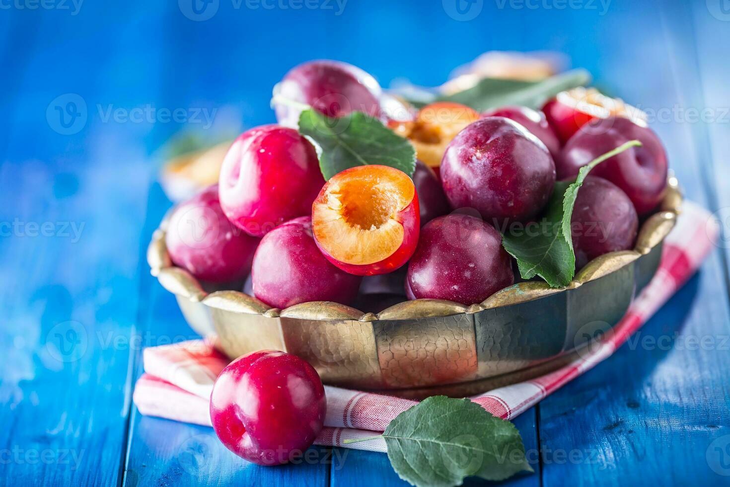 Pflaumen. frisch saftig Pflaumen im ein Schüssel auf ein hölzern oder Beton Tafel foto