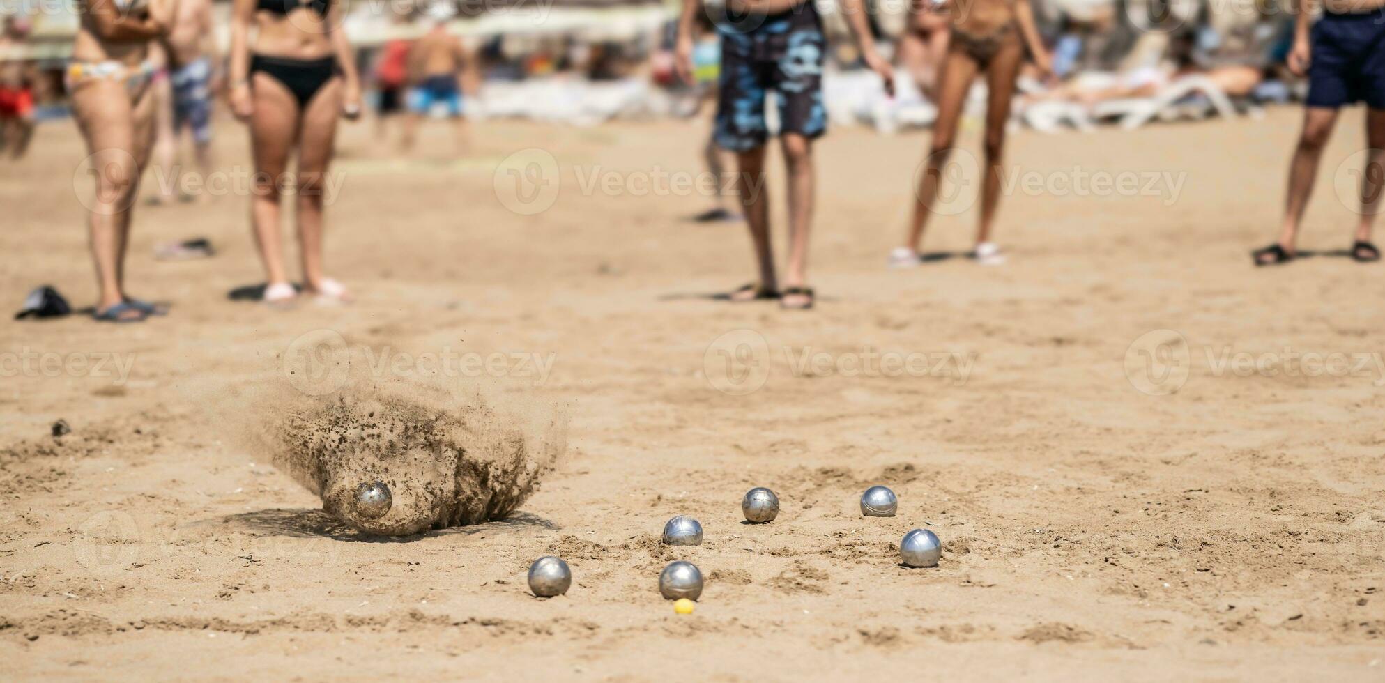 Petanque Bälle im das Sand durch das Meer während ein Spiel auf das Strand foto