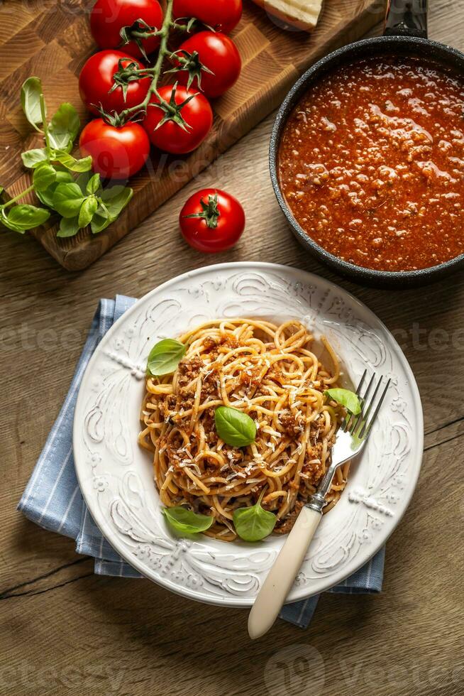 Italienisch Pasta Spaghetti Bolognese serviert auf Weiß Teller mit Parmesan Käse und Basilikum foto