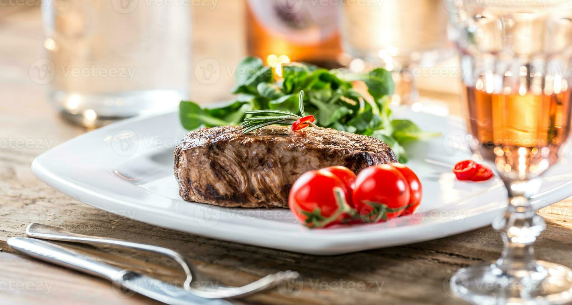 Rindfleisch Steak. saftig Rindfleisch Steak. Gourmet Steak mit Gemüse und Glas von Rose Wein auf hölzern Tabelle foto