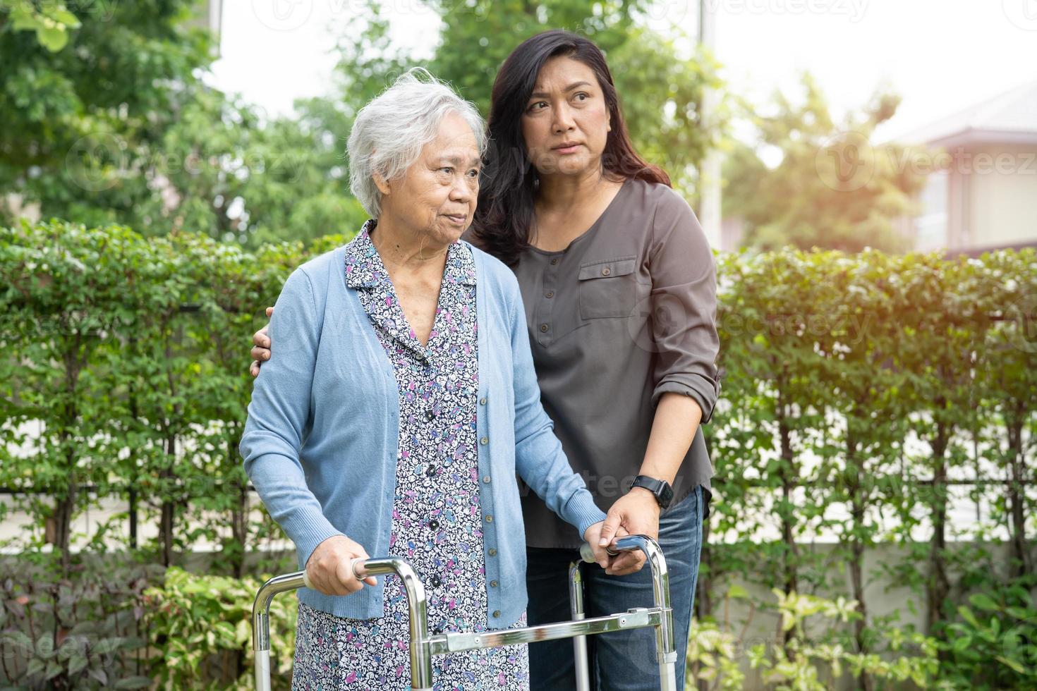 Hilfe und Pflege asiatische Senioren oder ältere alte Damen verwenden einen Walker mit starker Gesundheit, während sie im Park in einem glücklichen, frischen Urlaub spazieren gehen. foto