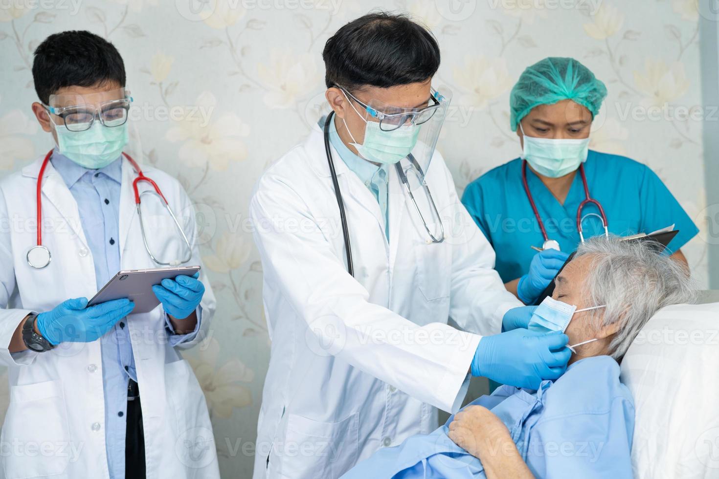 Asiatisches Ärzteteam überprüft alte ältere Dame auf Krankheit zur Motivation neuer Normalität zur Behandlung der Infektion mit Covid-19 Coronavirus auf der Krankenhausstation foto