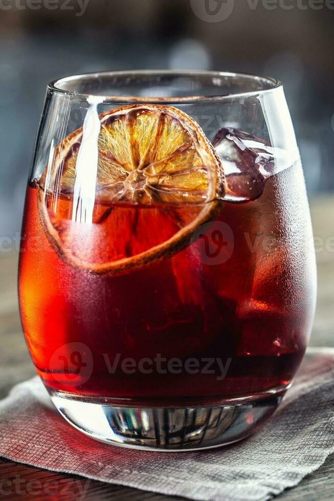 Negroni klassisch Cocktail und Gin kurz trinken mit Süss Wermut, rot bitter Likör und getrocknet Orange Garnierung foto