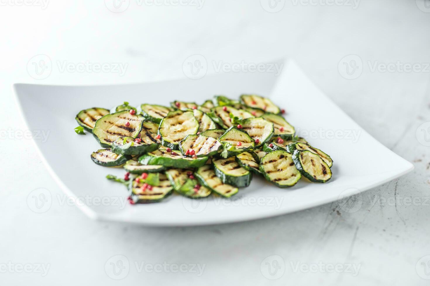 Zucchini. gegrillt Zucchini mit rot würzen auf Weiß Teller foto