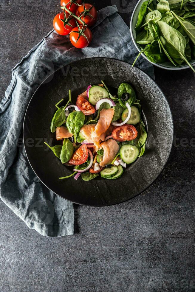 Lachs Salat mit Gemüse im Teller auf dunkel Küche Tabelle - - oben von Aussicht foto