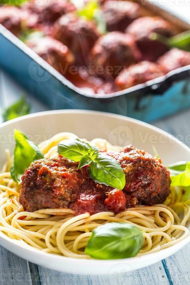 köstlich Italienisch Mahlzeit Fleisch Rindfleisch Bälle mit Pasta Spaghetti und Basilikum im Weiß Platte. foto