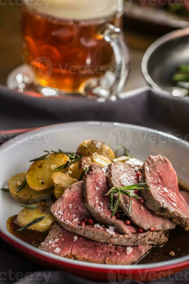 geschnitten Rindfleisch Filet geröstet Steak Kartoffeln Rosmarin und Entwurf Bier foto