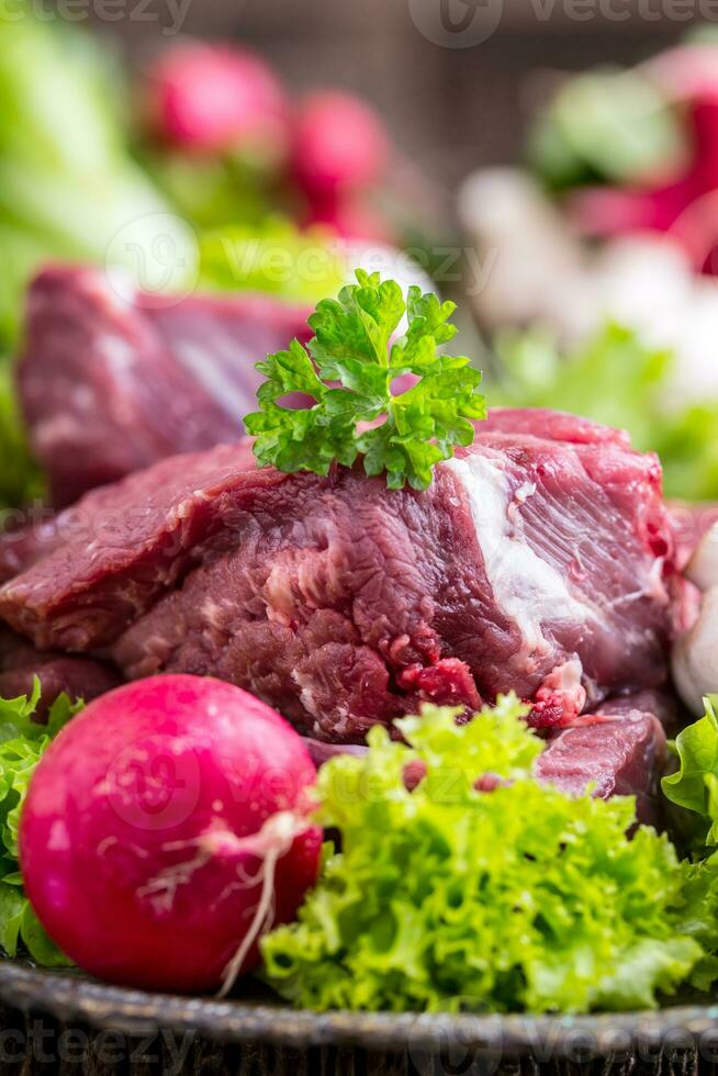 roh Rindfleisch Fleisch mit frisch Gemüse. geschnitten Rindfleisch Steak im Grüner Salat Salate Radieschen und Pilze. foto