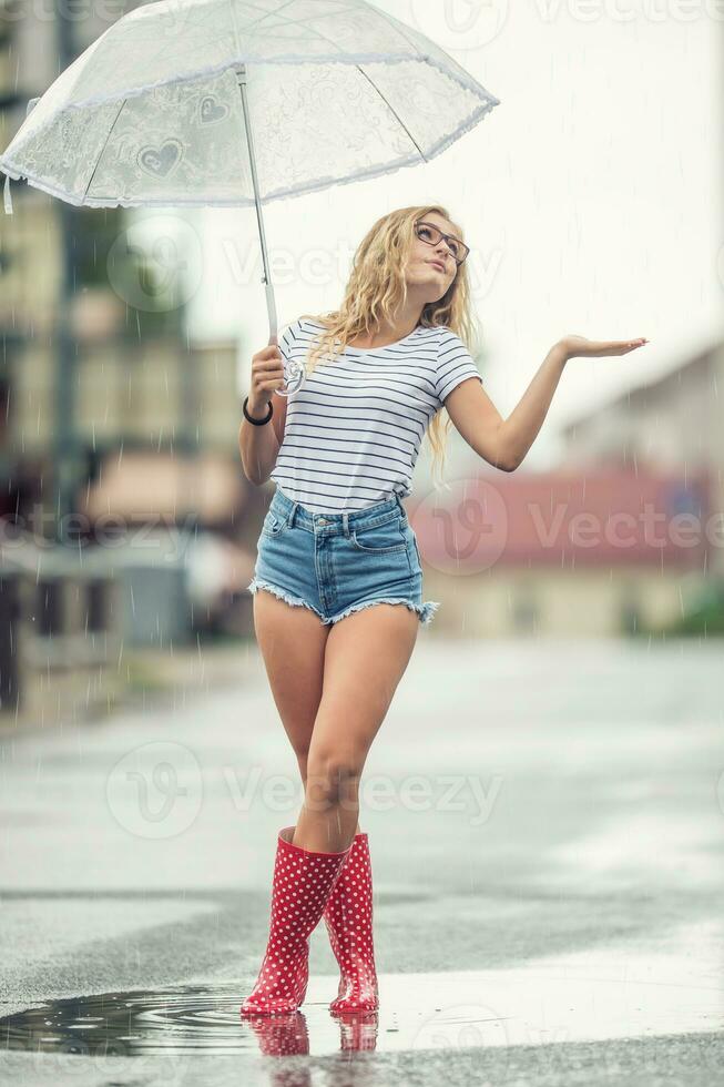 schön jung blond Mädchen halten Regenschirm im Sommer- Regen foto