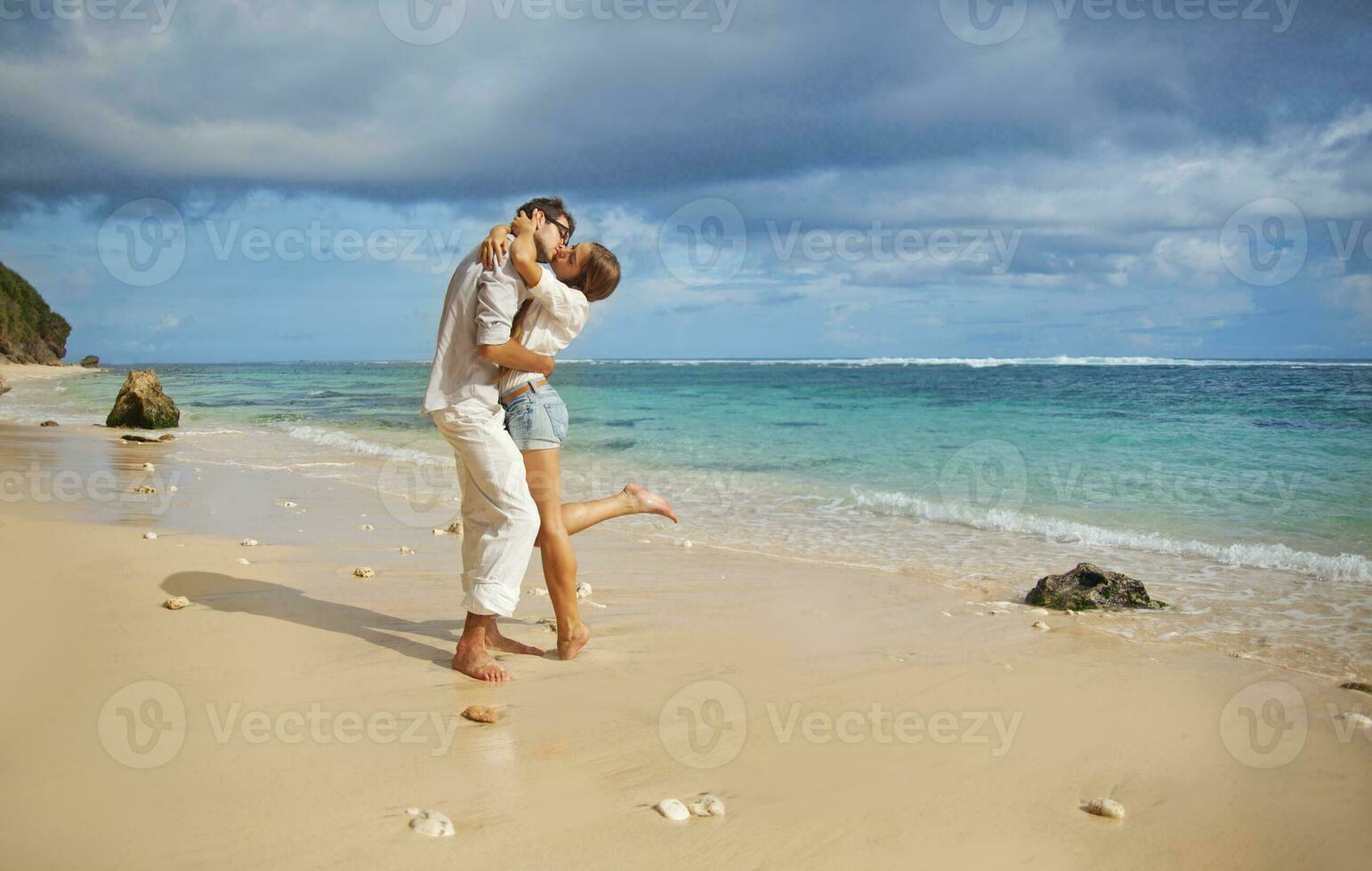 ein Mann und Frau sind umarmen auf das Strand foto