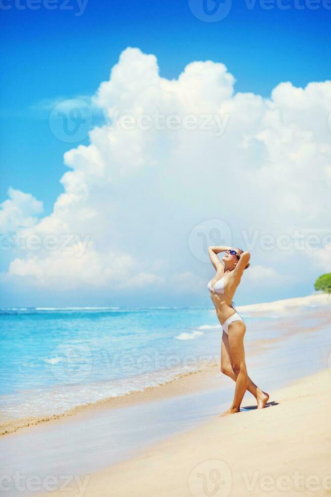 ein Frau im ein Bikini auf das Strand foto