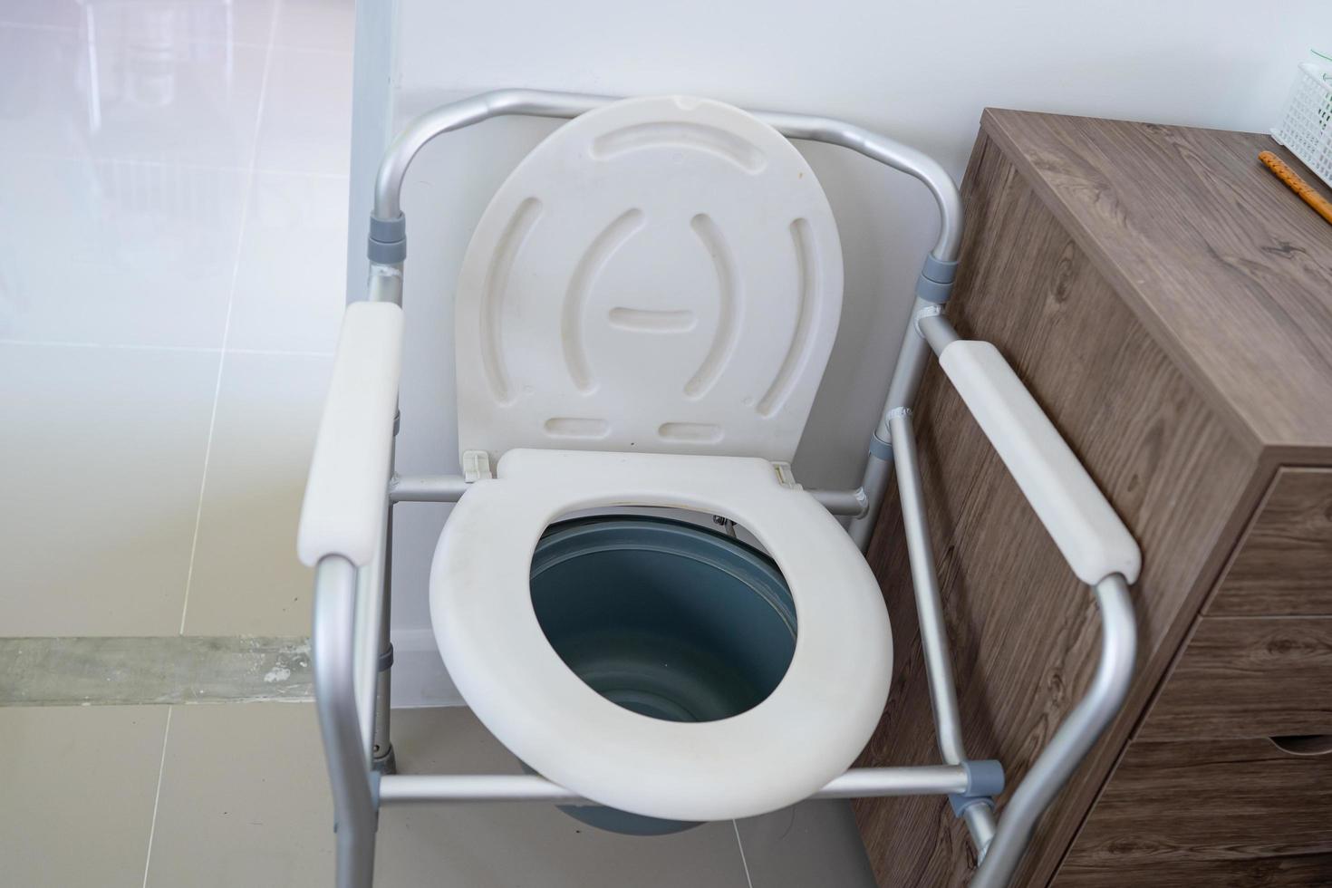 Toilettenstuhl oder mobile Toilette können sich im Schlafzimmer oder überall für ältere, alte Behinderte oder Patienten im Krankenhaus bewegen, gesundes, starkes medizinisches Konzept foto