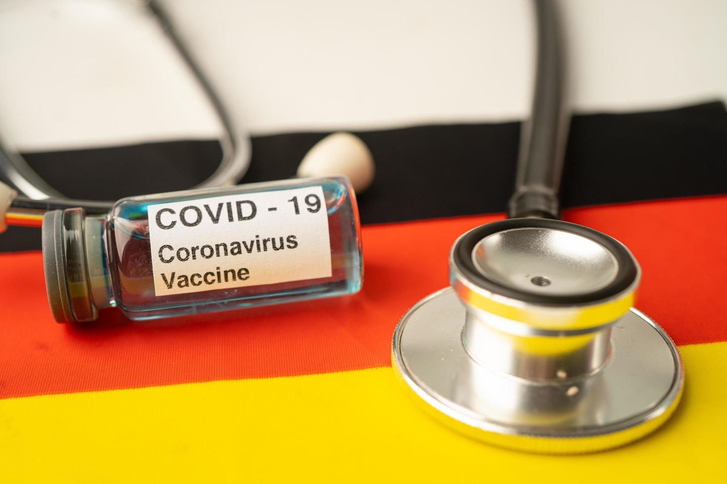 Stethoskop mit Covid-19-Coronavirus-Impfstoff auf deutscher Flagge. foto