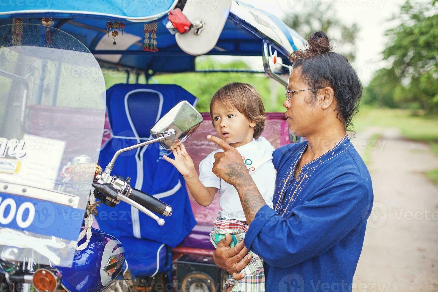 ein Mann und ein Kind sind suchen beim ein Motorrad foto