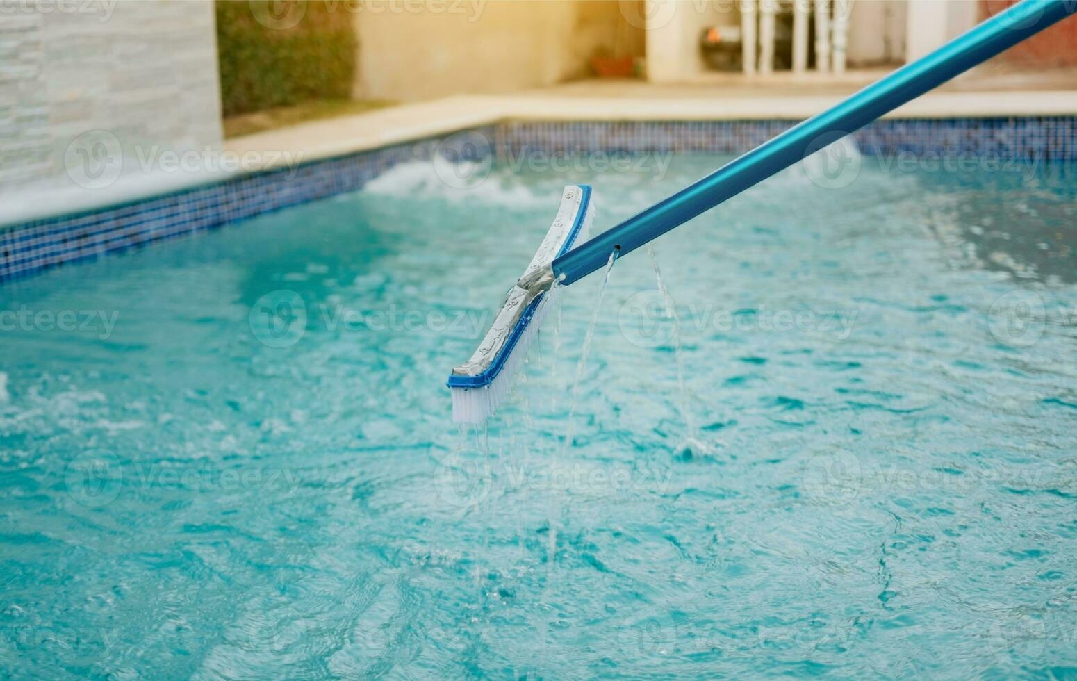 Schwimmen Schwimmbad Reinigung mit Bürste. Schwimmbad Bürste zum Mauer Reinigung, Arbeiter Reinigung ein Schwimmbad mit Besondere Bürste foto