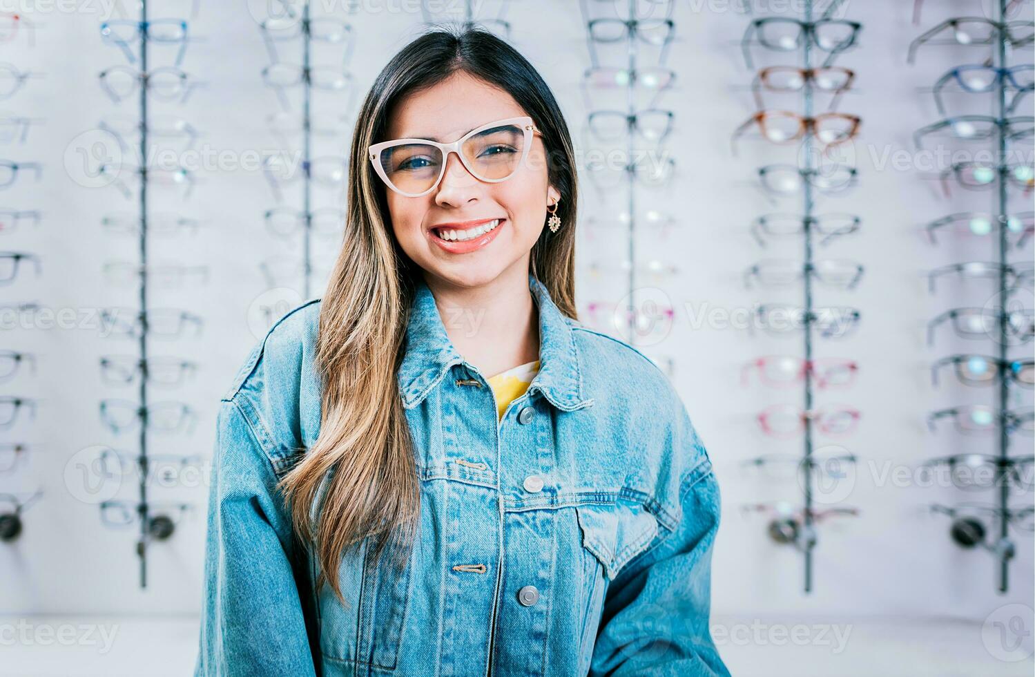 lächelnd glücklich Mädchen im Brille mit Geschäft Brille Hintergrund, Porträt von glücklich Mädchen im Brille im ein Brille Geschäft foto