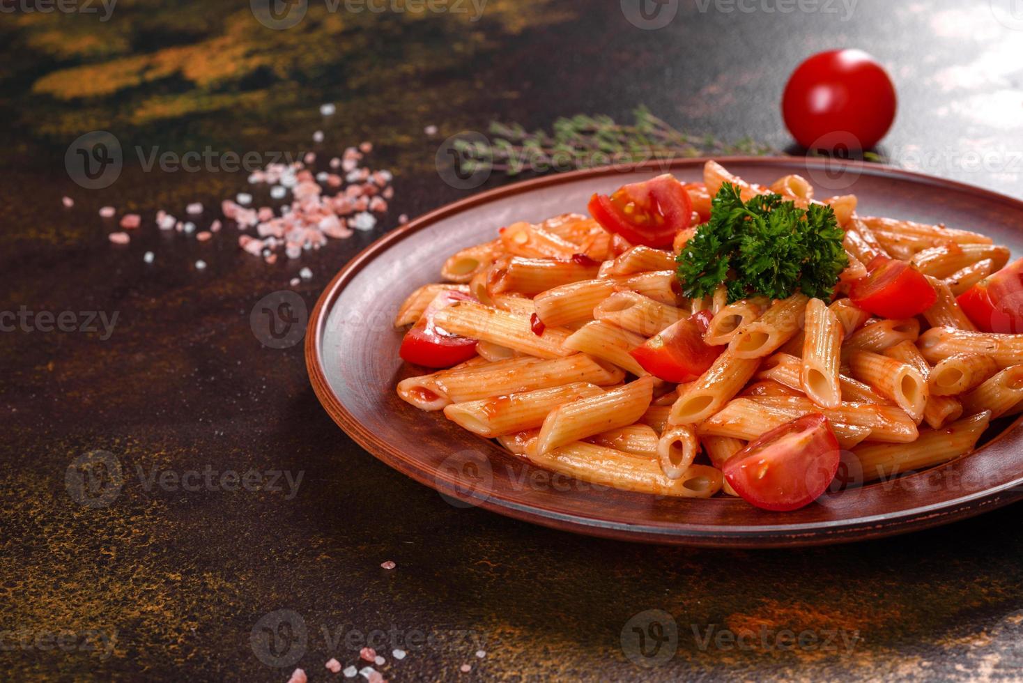 köstliche frische Paste mit Tomatensauce mit Gewürzen und Kräutern auf dunklem Hintergrund foto