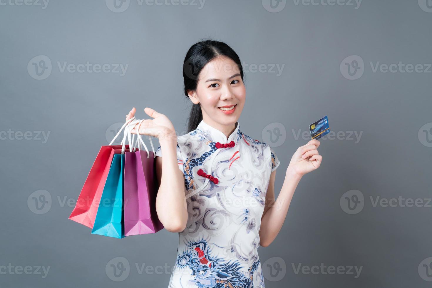 asiatische frau trägt chinesisches traditionelles kleid mit einkaufstasche und kreditkarte foto