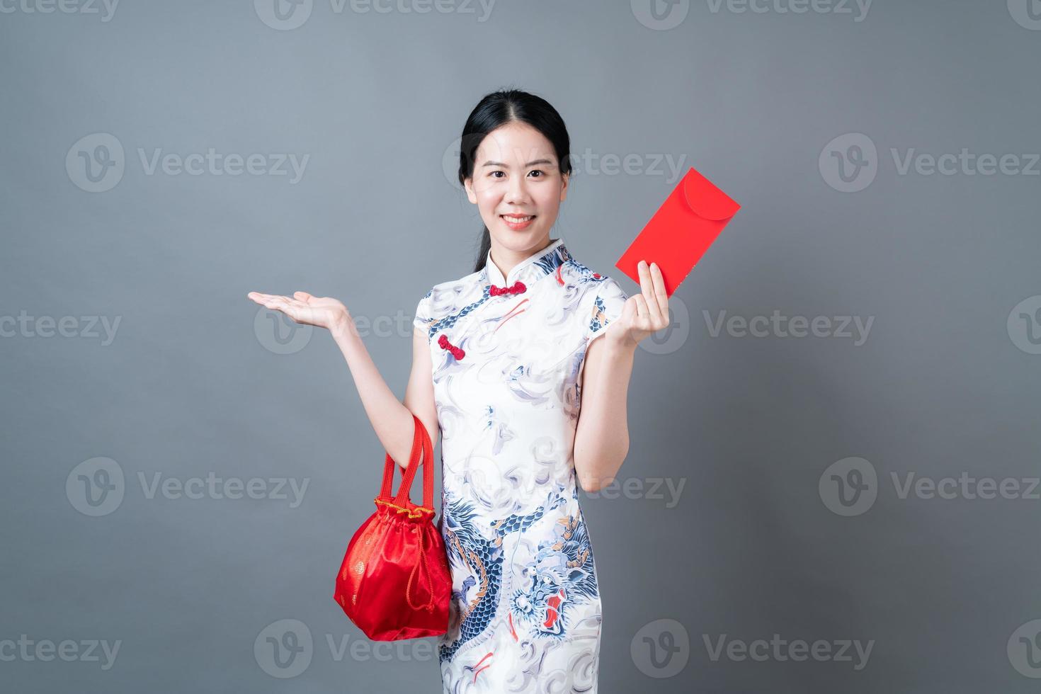asiatische Frau trägt chinesisches traditionelles Kleid mit rotem Umschlag oder rotem Paket foto