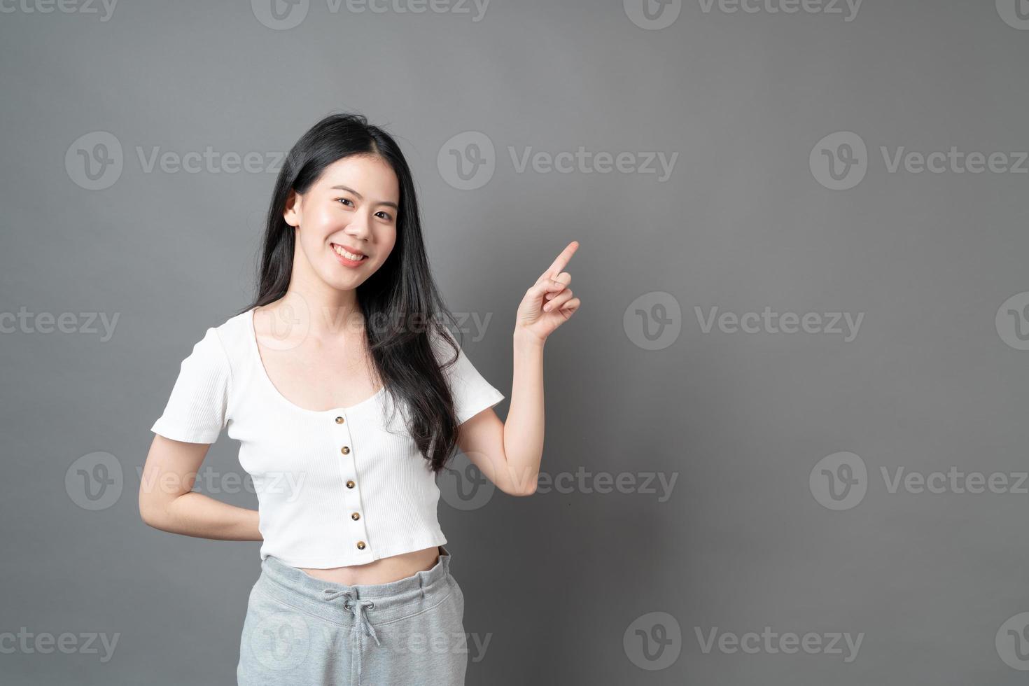 asiatische Frau mit lächelndem Gesicht und Hand präsentiert auf der Seite on foto