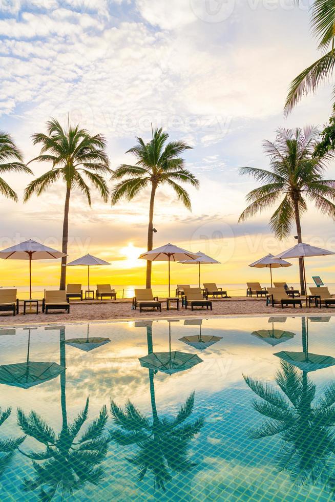 Sonnenschirm und Stuhl um den Pool im Hotelresort mit Sonnenaufgang am Morgen? foto