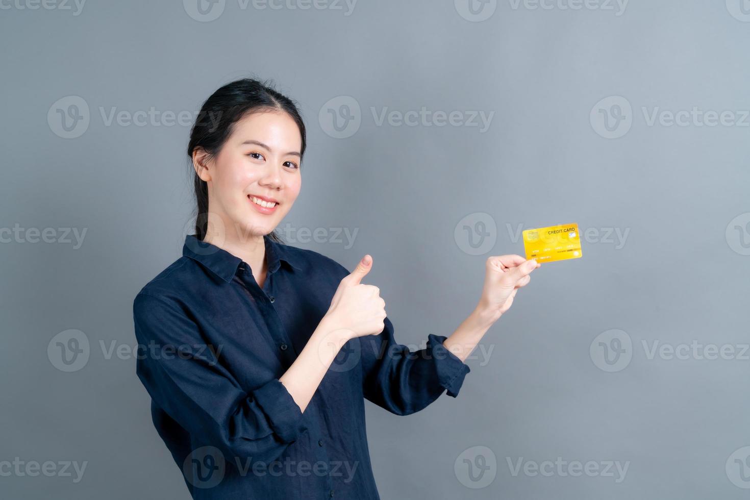 Porträt einer hübschen jungen Asiatin, die Kreditkarte zeigt showing foto