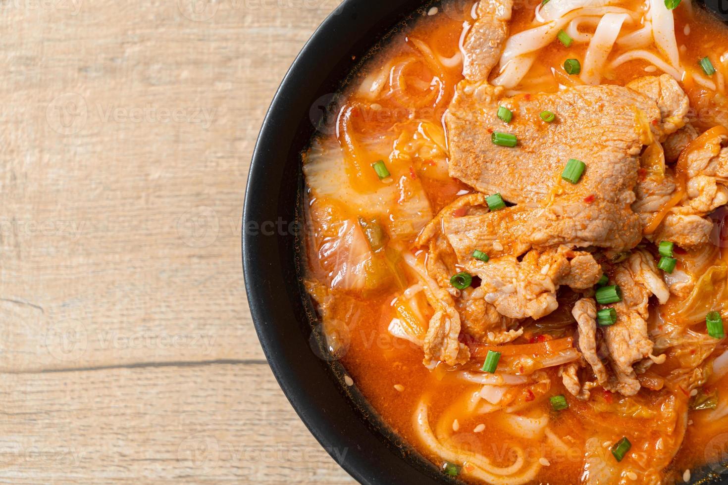 koreanische Udon-Ramen-Nudeln mit Schweinefleisch in Kimchi-Suppe foto