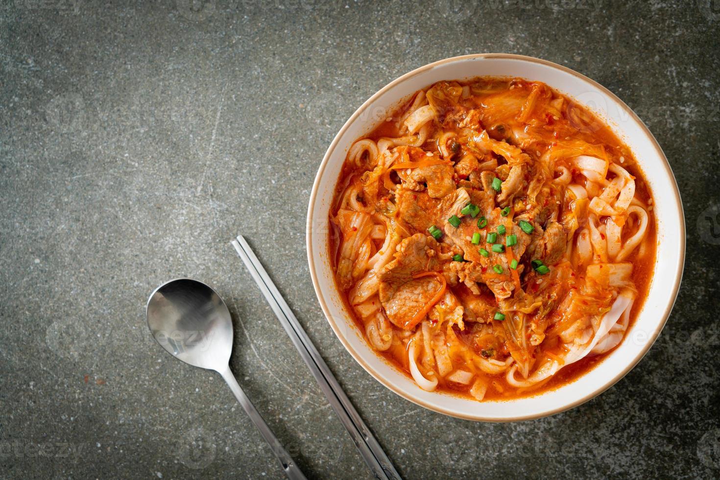 koreanische Udon-Ramen-Nudeln mit Schweinefleisch in Kimchi-Suppe foto