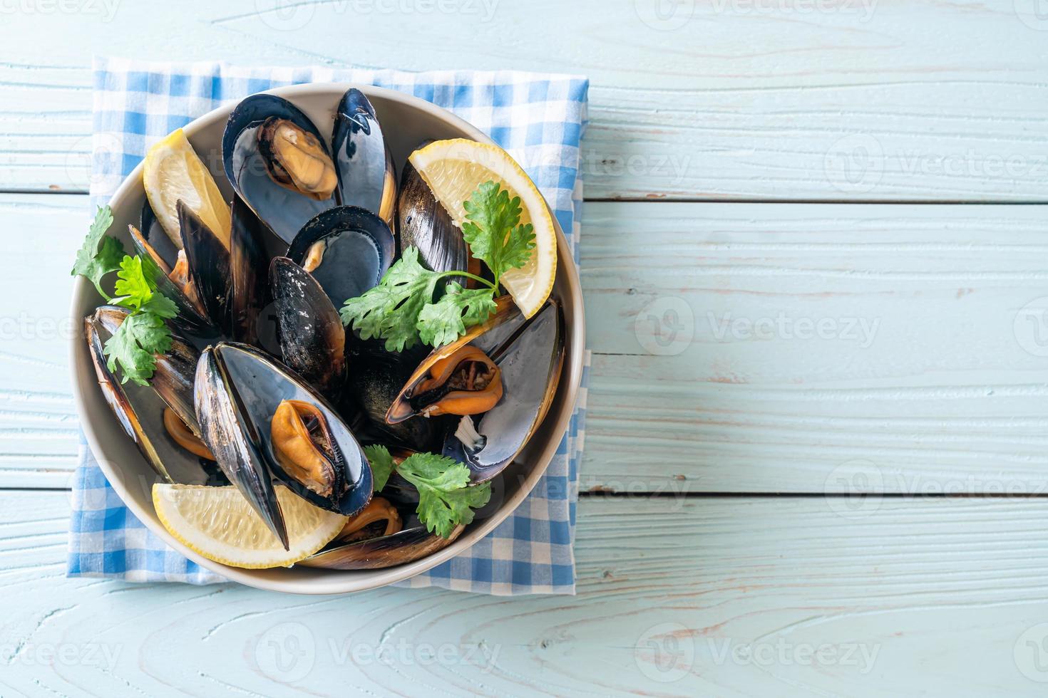 Muscheln mit Kräutern in einer Schüssel mit Zitrone foto