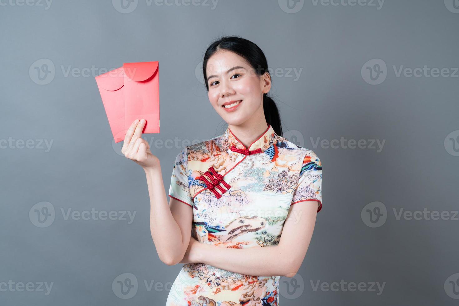 asiatische Frau trägt chinesisches traditionelles Kleid mit rotem Umschlag oder rotem Paket foto