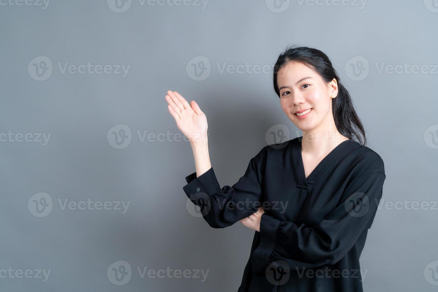 asiatische frau mit hand präsentiert auf der seite foto