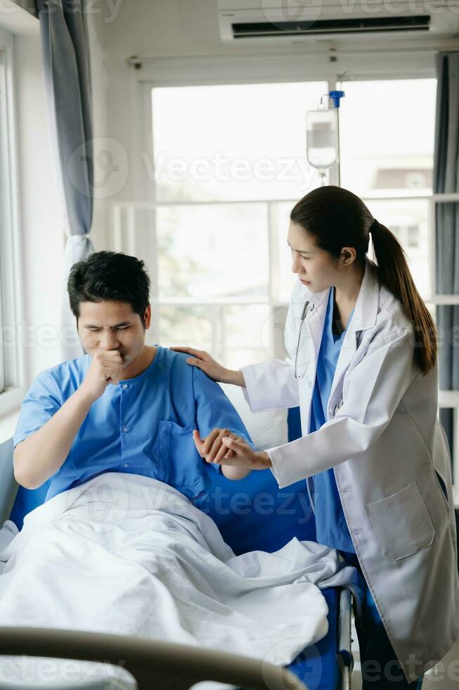Arzt und jung männlich geduldig Wer Lüge auf das Bett während Überprüfung Impuls, konsultieren und erklären mit Krankenschwester nehmen Hinweis im Krankenhaus foto