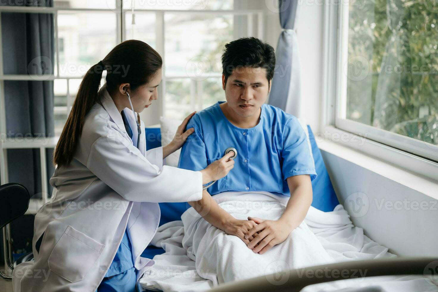 asiatisch männlich geduldig auf Bett während Arzt Hände von Überprüfung Prüfung seine Impuls zum Aufzeichnung das Behandlung Ergebnisse im Krankenhaus foto