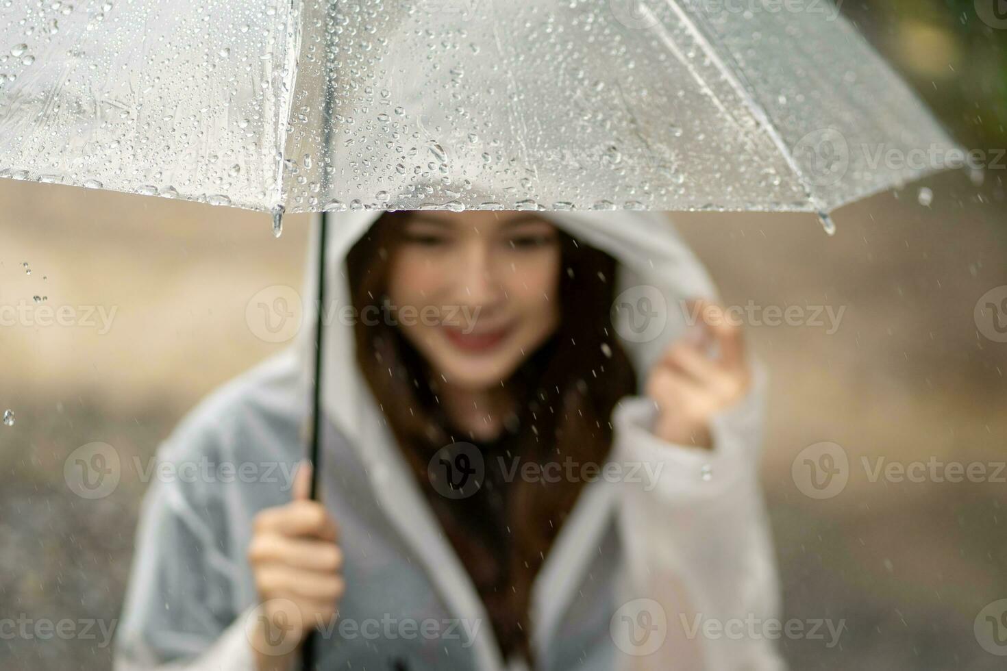 regnerisch Tag asiatisch Frau tragen ein Regenjacke draußen. sie ist glücklich. foto