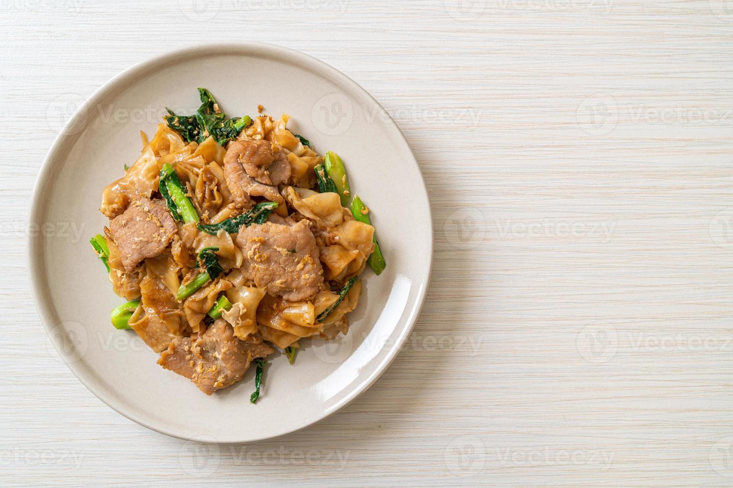 gebratene Reisnudeln mit schwarzer Sojasauce und Schweinefleisch und Grünkohl foto