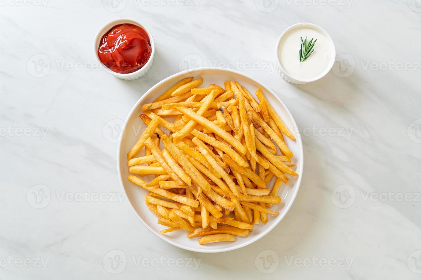 Pommes Frites mit Sauerrahm und Ketchup foto