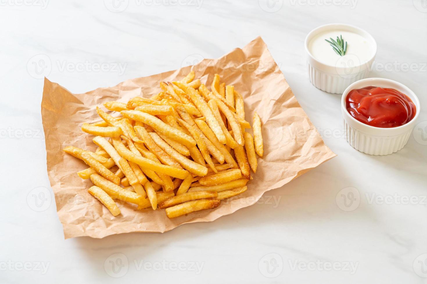 Pommes Frites mit Sauerrahm und Ketchup foto