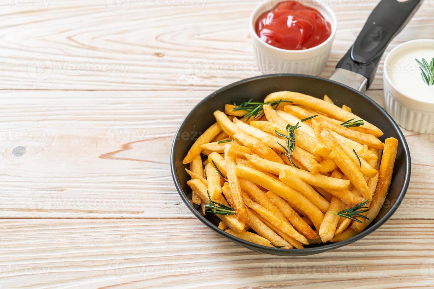 Pommes Frites mit Sauerrahm und Ketchup foto