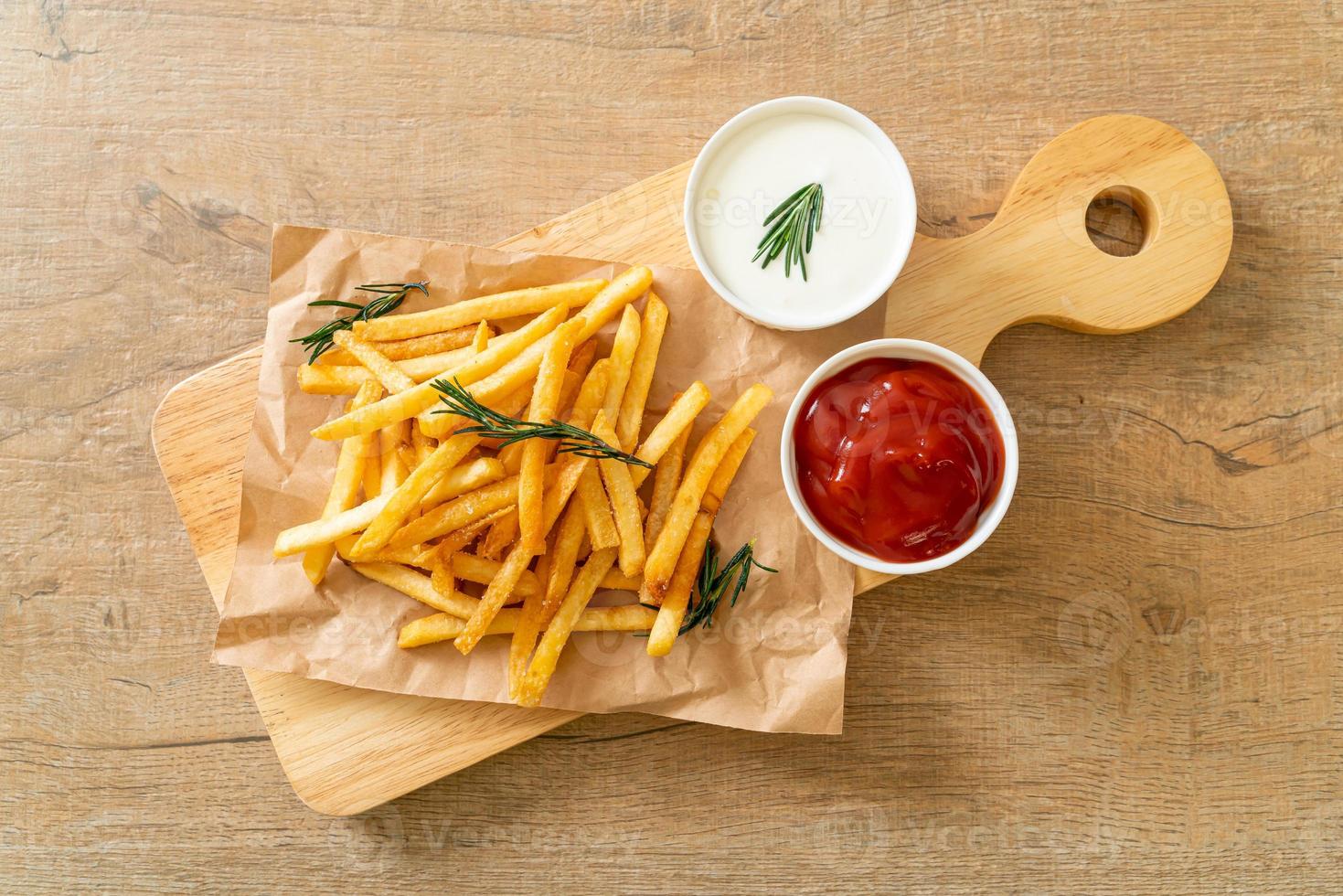 Pommes Frites mit Sauerrahm und Ketchup foto