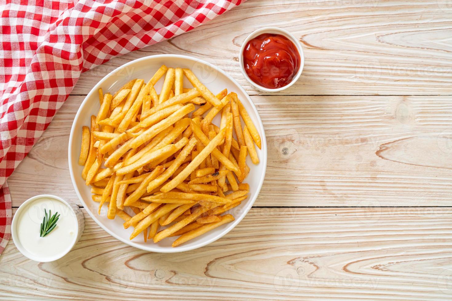 Pommes Frites mit Sauerrahm und Ketchup foto