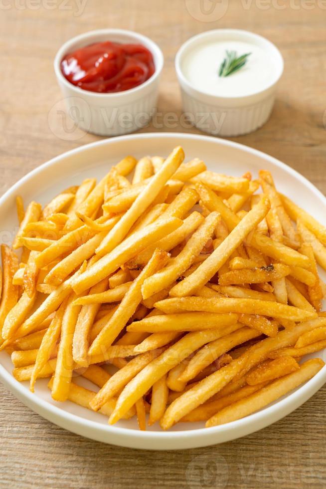 Pommes Frites mit Sauerrahm und Ketchup foto