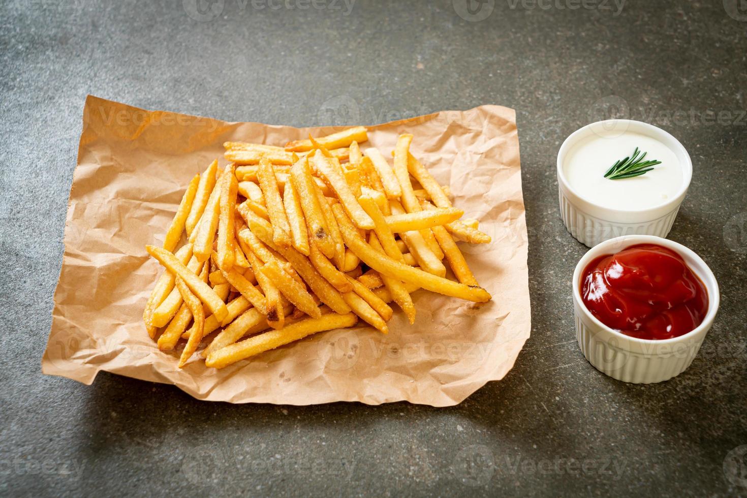 Pommes Frites mit Sauerrahm und Ketchup foto