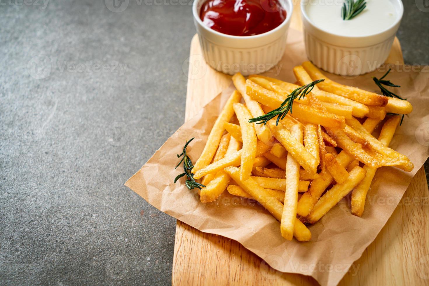 Pommes Frites mit Sauerrahm und Ketchup foto