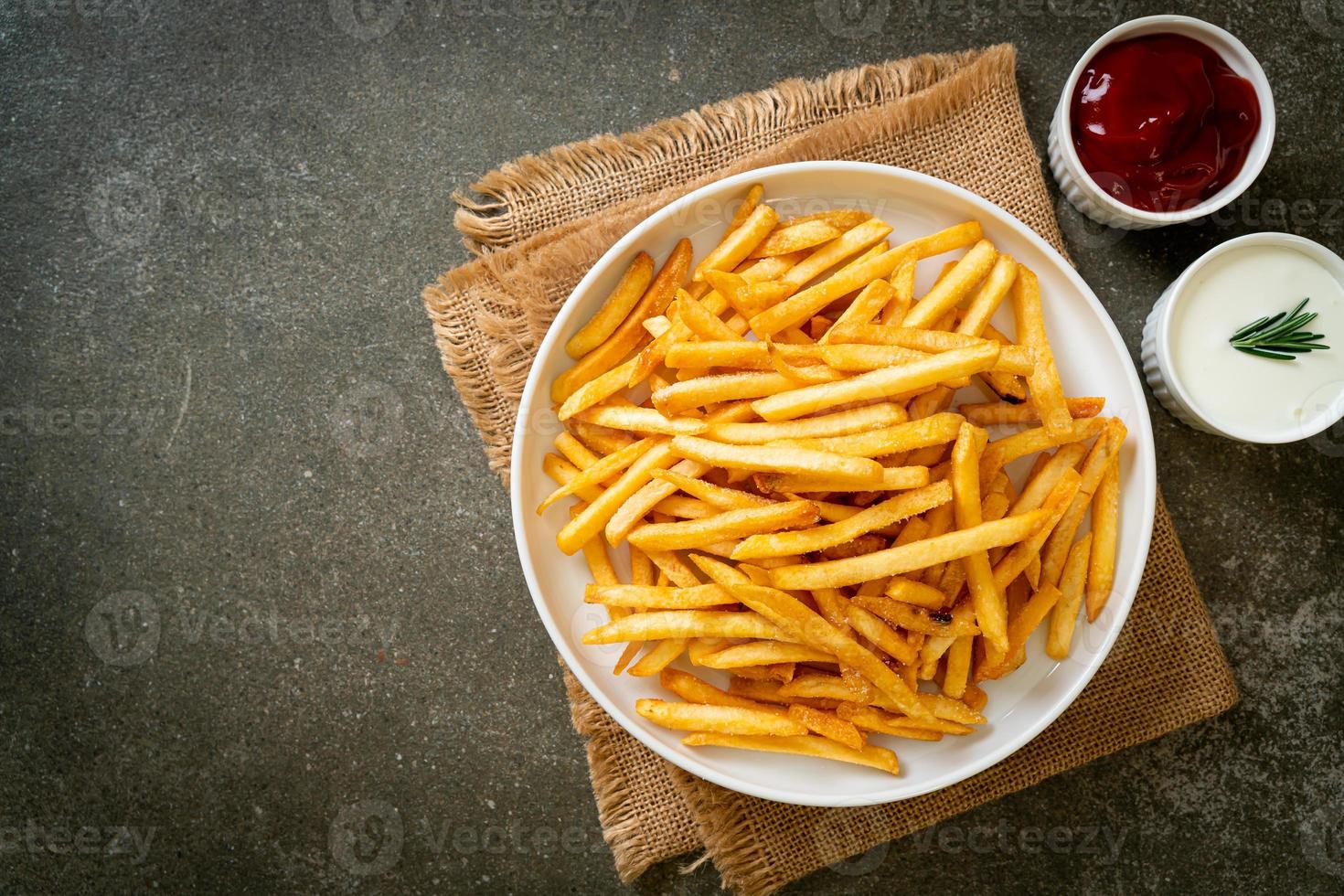 Pommes Frites mit Sauerrahm und Ketchup foto