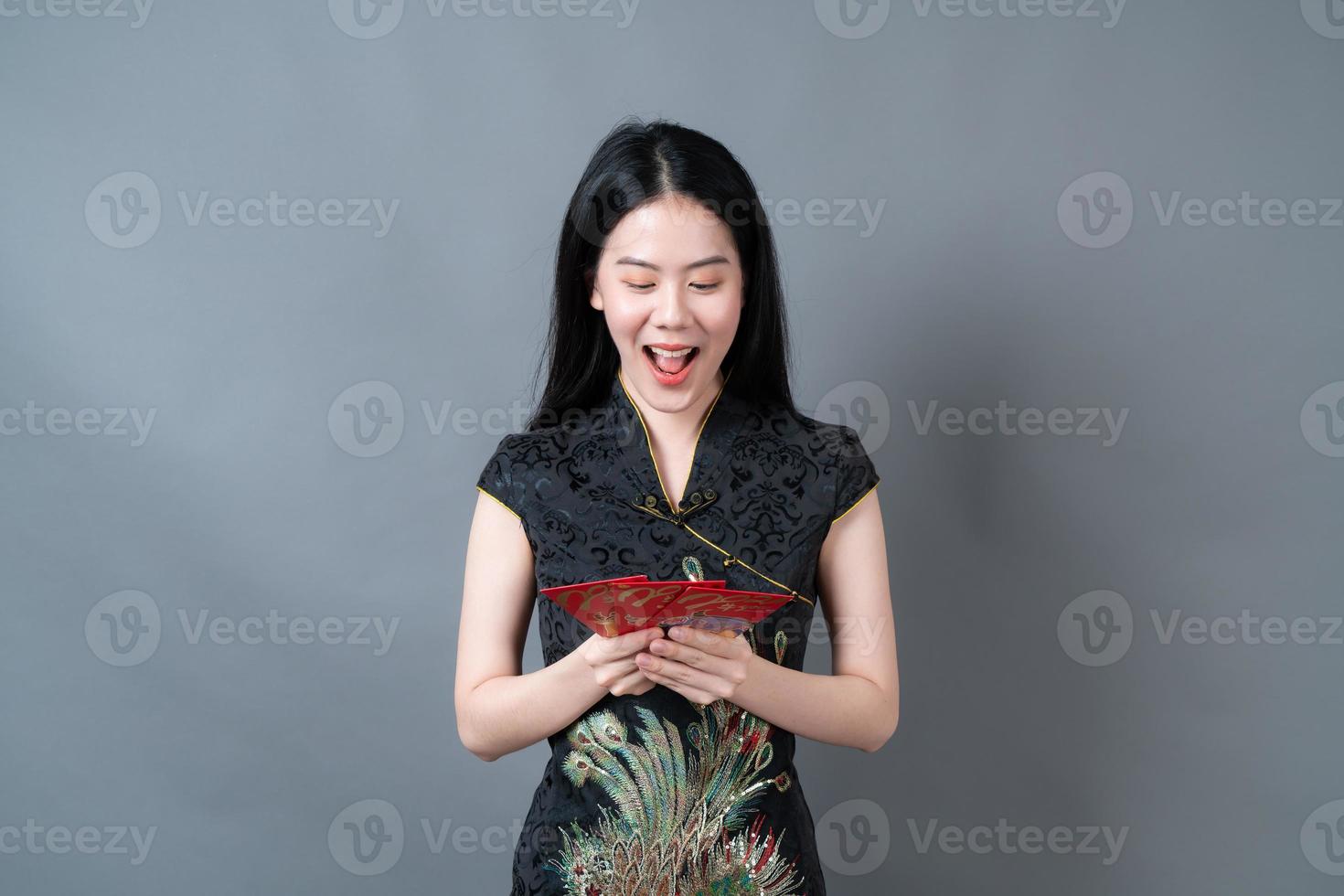 asiatische Frau trägt chinesisches traditionelles Kleid mit rotem Umschlag oder rotem Paket foto